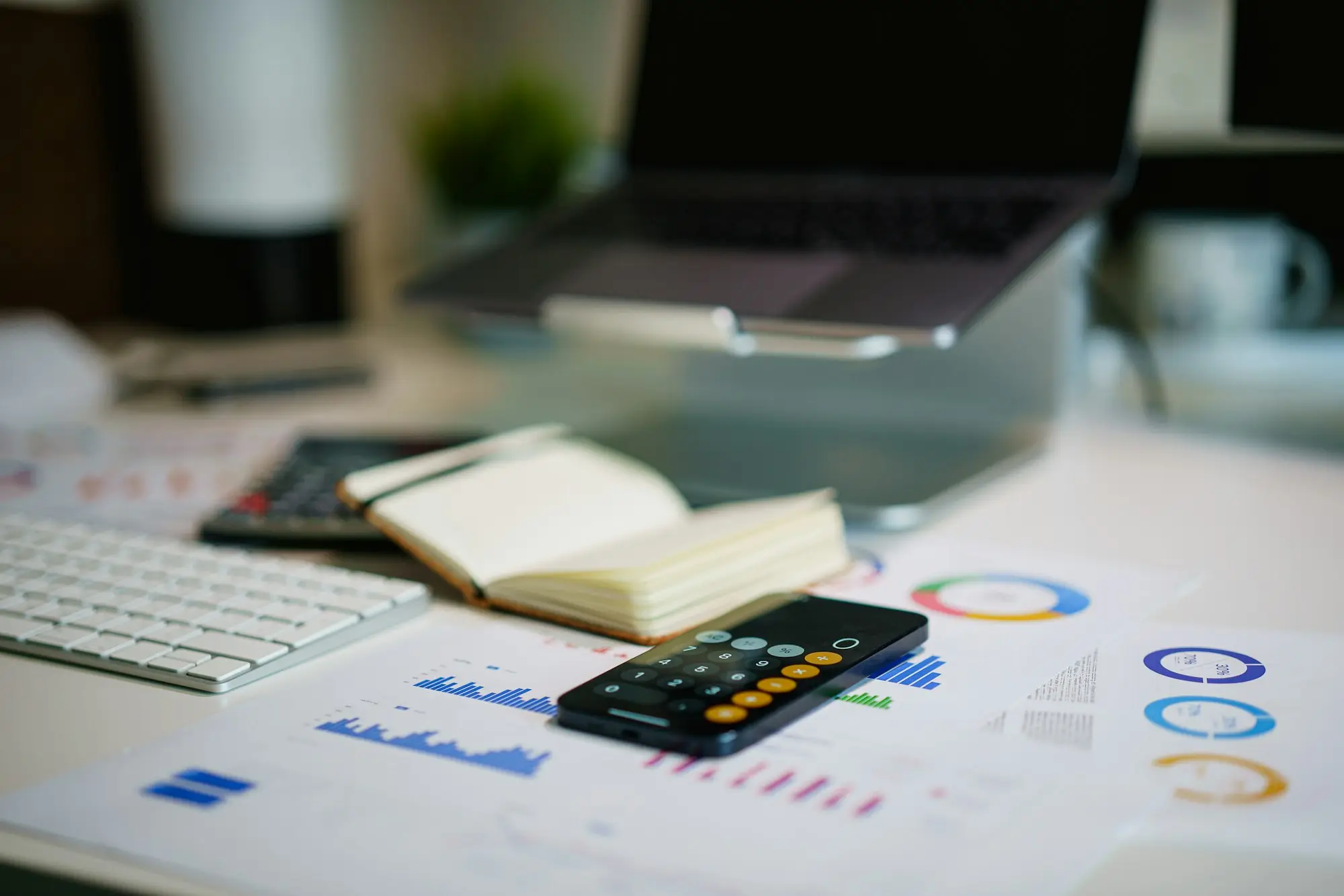 Accountant sorting business documents beside a laptop in a home office